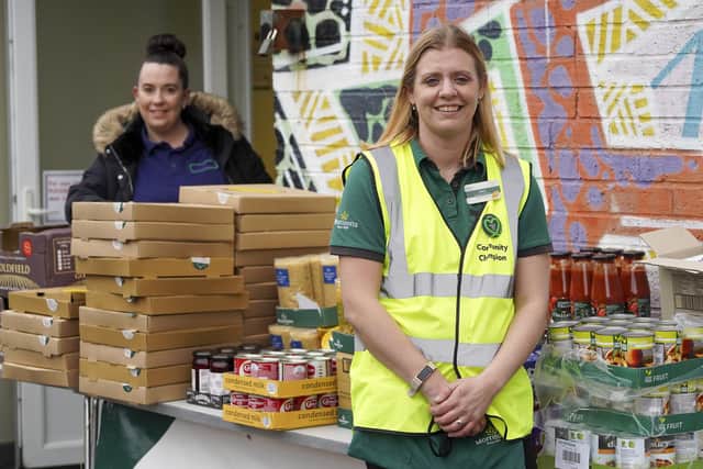 Lucy Gibson from Morrisons and Zoe Colton with some of the 150 pizza boxes that the supermarket are giving away to families at Lowedges Community Centre.  Picture Scott Merrylees