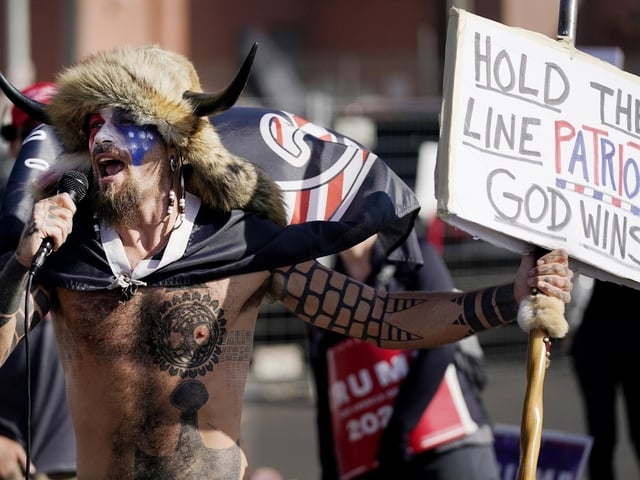 Jake Angeli, a supporter of President Donald Trump, speaks at a rally outside the Maricopa County Recorder's Office Saturday, Nov. 7, 2020, in Phoenix. Democrat Joe Biden defeated President Donald Trump to become the 46th president of the United States on Saturday, positioning himself to lead a nation gripped by the historic pandemic and a confluence of economic and social turmoil. (AP Photo/Ross D. Franklin)
