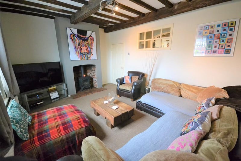 Lounge with feature  wood log burner and exposed beams