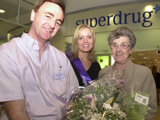 Hollyoaks actress Danielle Brent presents first customer Sylvia Atkins with a bunch of flowers from Store Manager Mark Hague as she opens the new Superdrug store in 2001