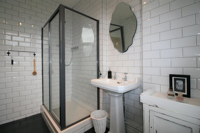 The subway tiled bathroom has a walk-in shower and cast iron bath with a separate wc.
