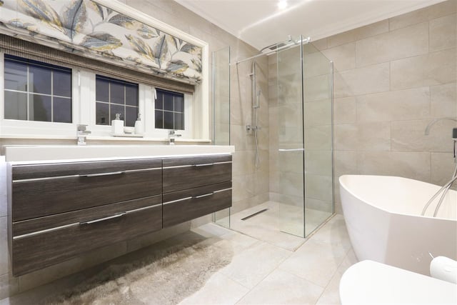 An "outstanding" Italian design bespoke bathroom with stunning walk-in shower and freestanding stone bath.