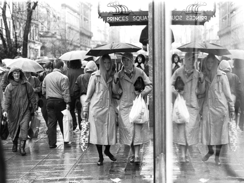 Heavy rain failed to stop the Glasgow bargain hunters outside Princes Square in Buchanan Street, December 1987.