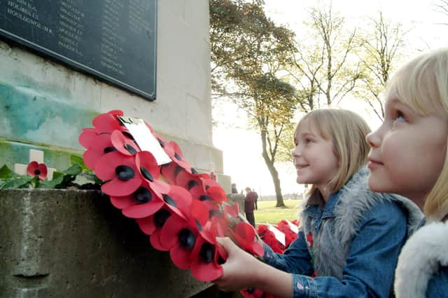 2006: youngsters Lauren, ten,  and Jessica Walter, eight, look at the names on the cenotaph at the remembrance day service at Titchfield Park in Hucknall
