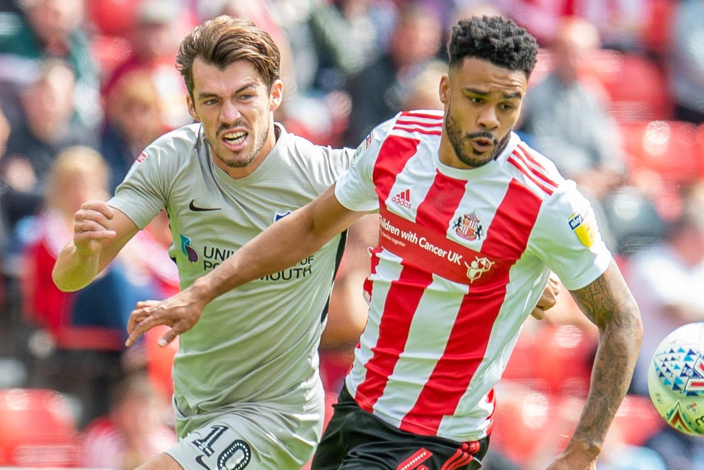 John Marquis (#10) of Portsmouth FC and Jordan Willis (#4) of Sunderland AFC during the EFL Sky Bet League 1 match between Sunderland and Portsmouth at the Stadium Of Light, Sunderland, England on 17 August 2019.
