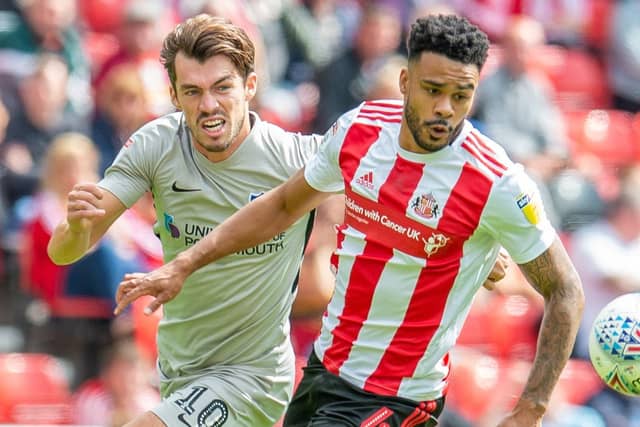 John Marquis (#10) of Portsmouth FC and Jordan Willis (#4) of Sunderland AFC during the EFL Sky Bet League 1 match between Sunderland and Portsmouth at the Stadium Of Light, Sunderland, England on 17 August 2019.