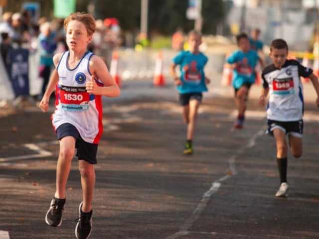 Boys in the junior run cross the finishing line on Saturday. Photo: Gary Tiller.