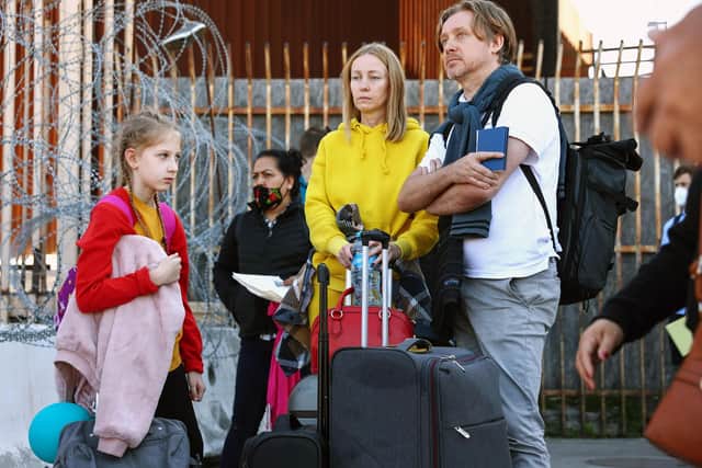 MARCH 22: A Ukrainian family who fled Kyiv, Ukraine, on March 24th wait with their luggage before being allowed to cross the San Ysidro Port of Entry into the United States to seek asylum on March 22, 2022 in Tijuana, Mexico. U.S. authorities have recently been allowing Ukrainian refugees to enter the U.S. at the Southern border in Tijuana with permission to remain in the U.S. on humanitarian parole for one year. (Photo by Mario Tama/Getty Images)