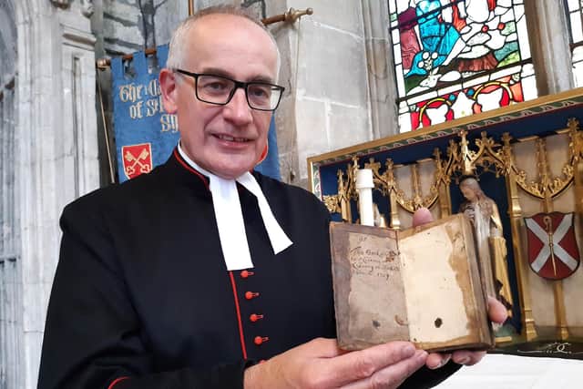 Rev Canon Keith Farrow with the 300 year old book The Faith and Practice of a Church of England Man