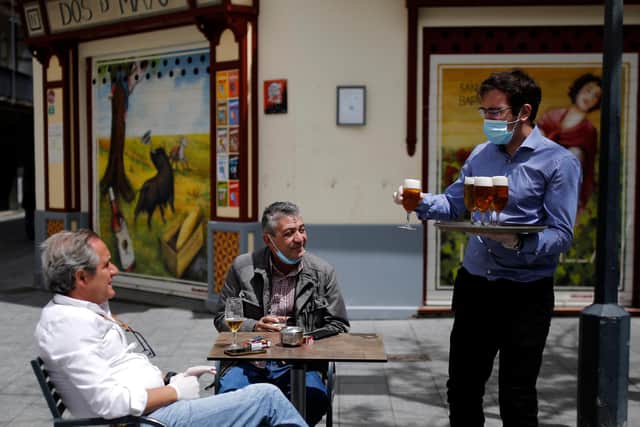SEVILLE, SPAIN - MAY 11: A waiter serves cups of beer at a terrace of a bar on May 11, 2020 in Seville, Spain. Some parts of Spain have entered the so-called "Phase One" transition from its coronavirus lockdown, allowing many shops to reopen as well as restaurants who serve customers outdoors. Locations that were harder hit by coronavirus (Covid-19), such as Madrid and Barcelona, remain in a stricter "Phase 0" quarantine. (Photo by Marcelo del Pozo/Getty Images)