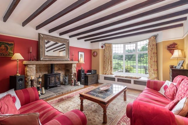 The large lounge provides a cosy space to relax with views out to the garden, and encompasses a number of period features, including an oak panelling on the roof and an impressive stone fireplace at its heart.
