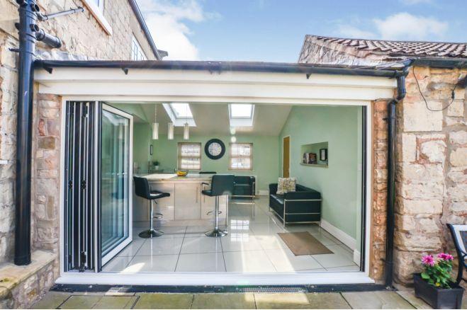 The family room is the perfect place to relax. Bifold doors open to offer a lovely view of the stunning garden.