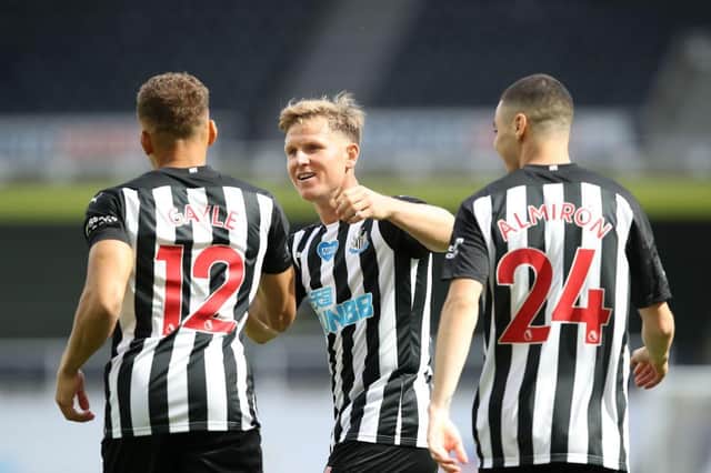 Newcastle United's English striker Dwight Gayle (L) celebrates with Newcastle United's Scottish midfielder Matt Ritchie (C) and Newcastle United's Paraguayan midfielder Miguel Almiron (R) after scoring a goal during the English Premier League football match between Newcastle United and Liverpool at St James' Park in Newcastle-upon-Tyne, north east England on July 26, 2020.