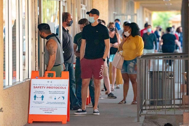People wait in line to vote at a polling place at the Scottsdale Plaza Shopping Center, in Scottsdale, Arizona.