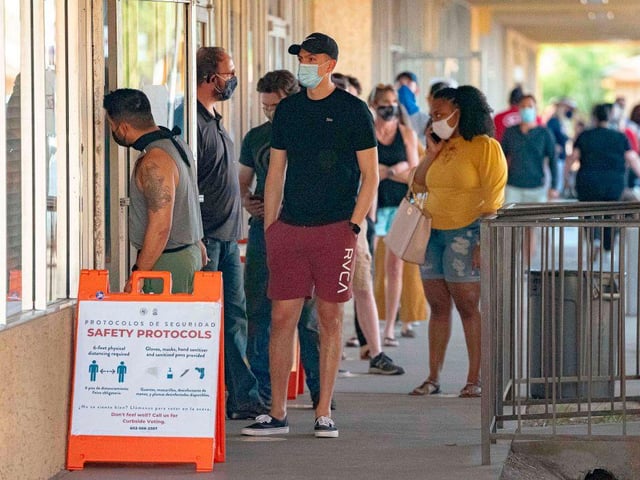 People wait in line to vote at a polling place at the Scottsdale Plaza Shopping Center, in Scottsdale, Arizona.