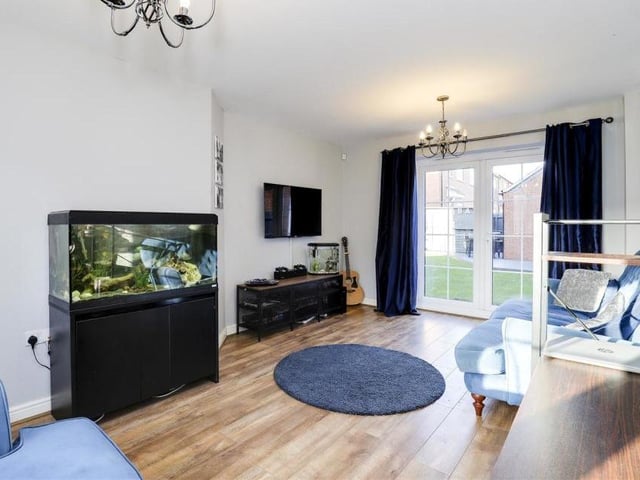 Our first look at the living room reveals a bright, airy space. It has laminate flooring, a wall-mounted radiator, a TV point and a uPVC double-glazed window to the front of the property. Double-glazed French doors lead to the back garden.
