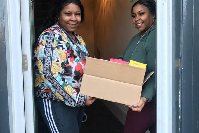 Twins Chandelle Hardy and Chanday Abrahams who are parents, with seven children in the house, getting a food parcel delivery