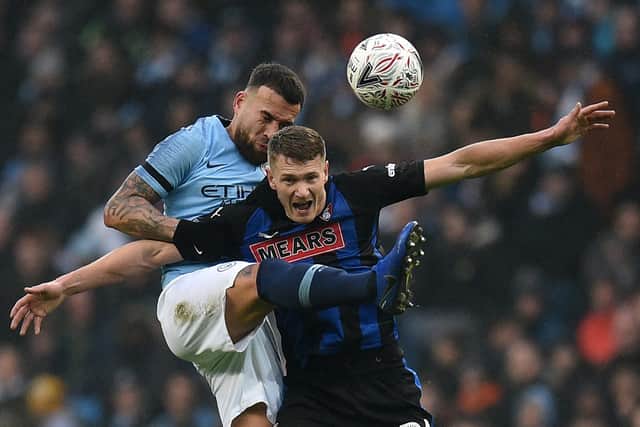 Manchester City's former defender Nicolas Otamendi vies with Rotherham striker Michael Smith in the FA Cup.