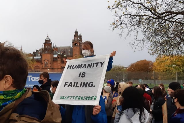 An activist with a sign which reads: "Humanity is failing."