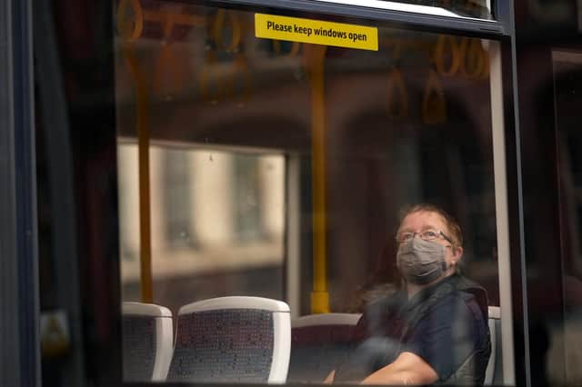 A member of the public sitting in a bus wears a pandemic face mask (Photo by Christopher Furlong/Getty Images)
