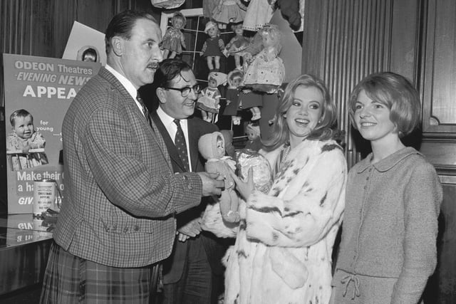 The actress Hayley Mills presents a doll to Ian MacArthur for the children's ward of Nazareth Hospital as part of the Evening News Christmas appeal in 1965.