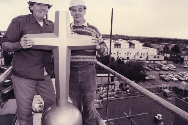 Builder Tony Rymer fits the new cross on top of the new United Reformed church in Fareham, 1993. The News PP4687