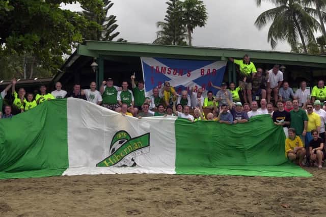 Hibs fans assemble for a picture, with a Tamson's Bar flag visible in the background