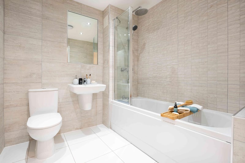 Family bathroon with white three piece suite and over bath shower.