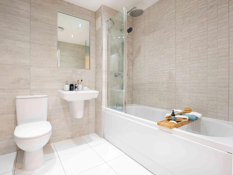 Family bathroon with white three piece suite and over bath shower.