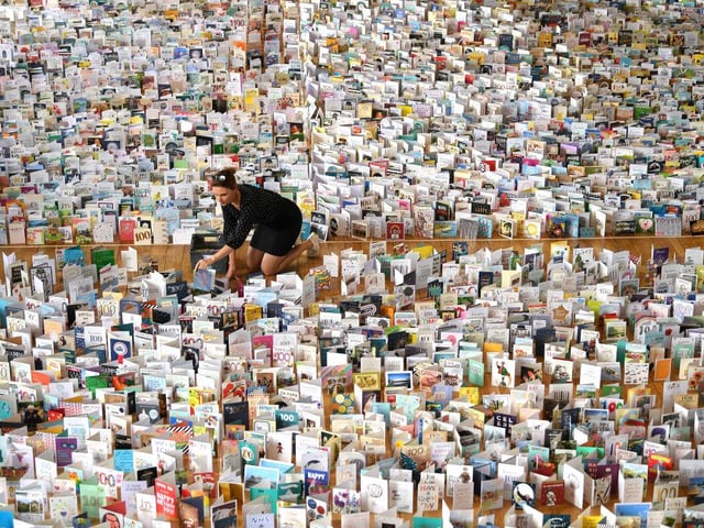 Mandy Alison adds to the thousands of birthday cards sent to Captain Tom Moore for his 100th birthday on April 30, 2020, which were displayed in the Hall of Bedford School. (Photo by Shaun Botterill/Getty Images)