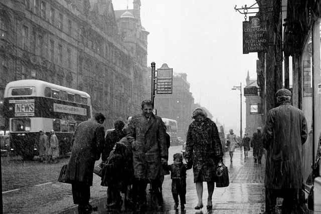Pedestrians make their way through snow storms on North Bridge in February 1964.