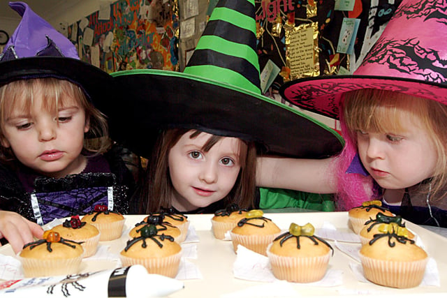 Holly Farbrother 2, Shauna Bailey 3, and Kira Morning 4 making spider cakes at  at the Hucknall Day  Nursery Halloween Fancy dress in 2006