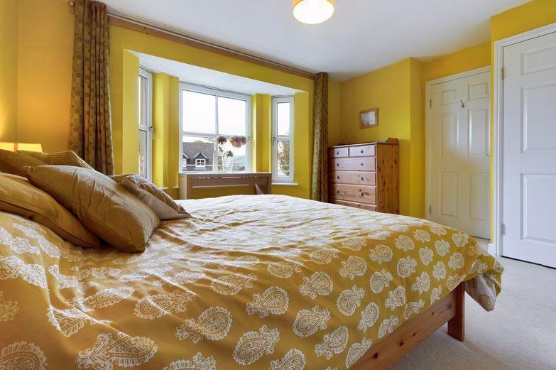 Guest bedroom is a sunny room with built in wardrobes and a bay window offering an outlook across to the hills.
