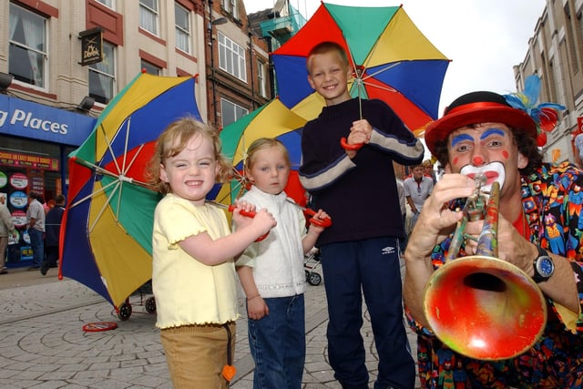 Sunshine, smiles and street entertainment. What more could you want in 2003. Marco the Clown is pictured with Rachel Milliken, Kelsey Gardner, and Liam Hutchinson.