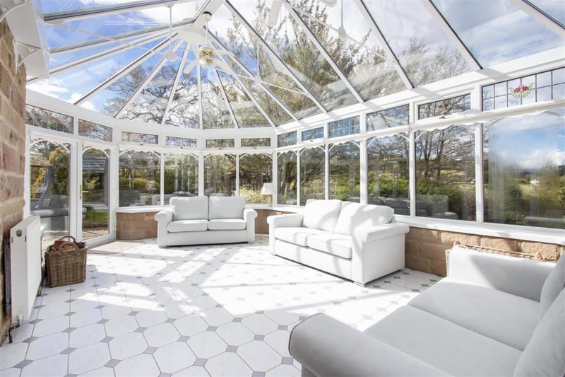 The large conservatory, accessed from the living room, enjoys 'the most idyllic views'.
