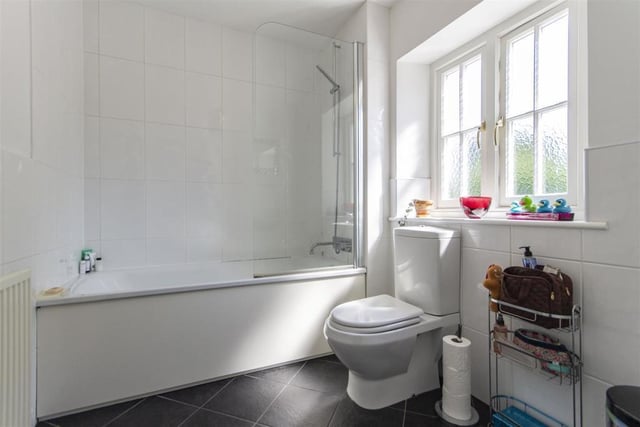 The bathroom has fully tiled walls and floor and is fitted with a white suite comprising shower cubicle with mixer shower, bath, wash basin and wc.