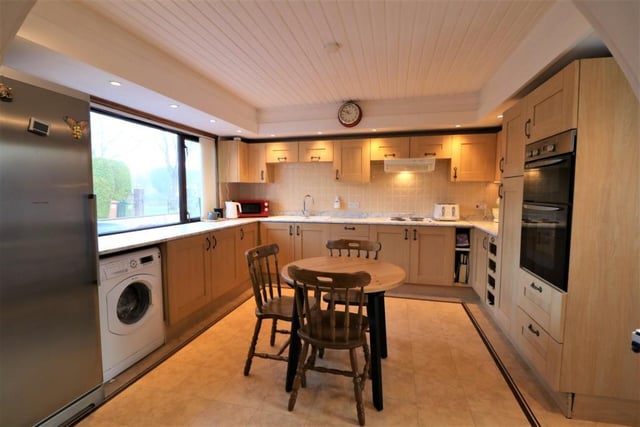 The kitchen has an array of base and wall mounted units, contrasting worktops and a selection of integrated appliances.