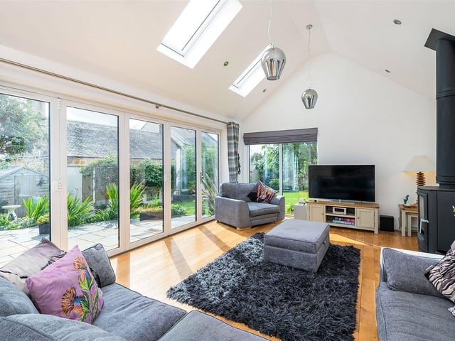 The open plan living room has under floor heating, stove and vaulted ceiling. Bi-folding glazed doors lead to the garden terrace.