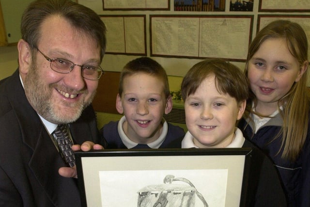 Kevin Hughes MP, receives the picture of a miners lamp from l/r: Gerry O'Malley (10), Steven Collins (11) and Leah Kirkby (10) at Bentley New Village School in January 2001