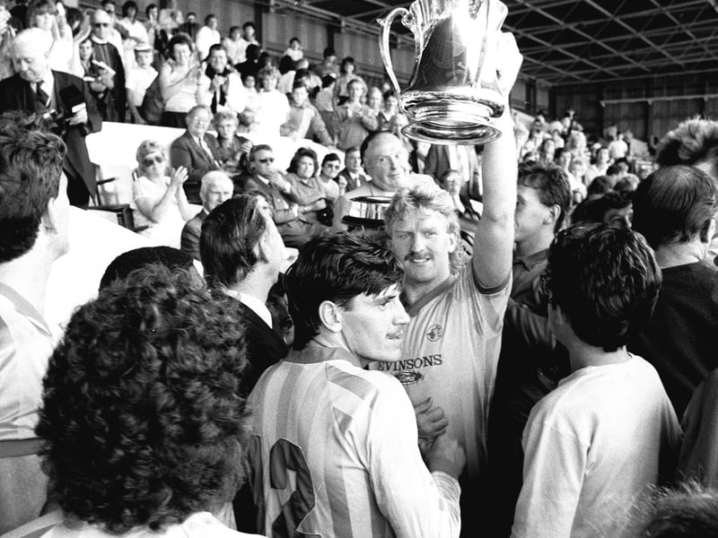 George Foster lifts the County Cup after victory over Forest.