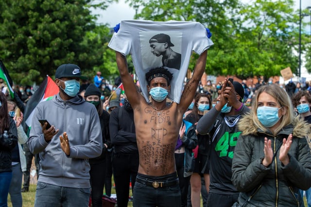 A marcher holds up a T-shirt with the image of US rapper Tupac Shakur