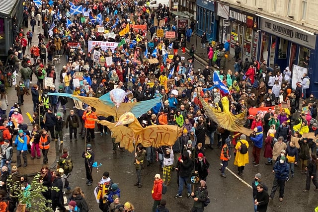 Activists carrying giant paper birds marching down Sauchiehall Street in Glasgow.