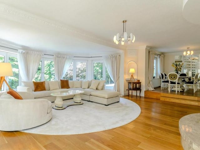 The fine, bright sitting room, next to the dining room, features a central multimedia platform with a marble surround. There is also a large bay window, providing views across the grounds and surrounding woodland, with French doors leading outside. Next door is a pleasant sun room.