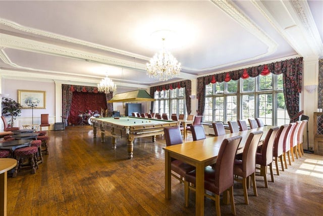 Currently used as an entertainment room, this impressive ball room features a pool table, stage area, and a wealth of seating, making it perfect for parties.