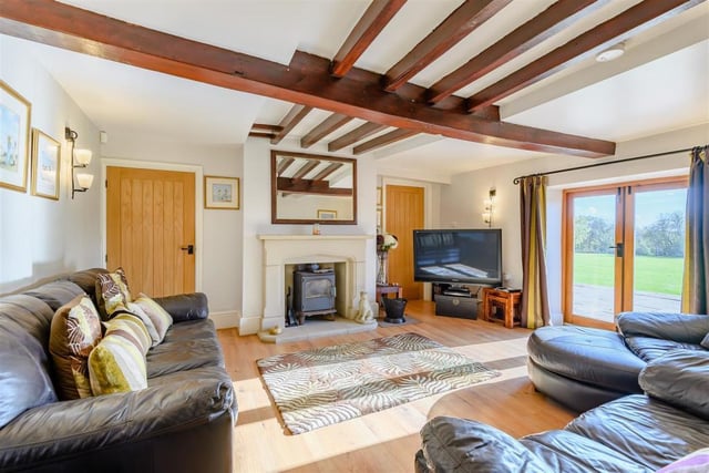 The lovely lounge has French doors leading out on to the substantial patio. It also features a stunning stone fireplace with inset multi-fuel stove, laminate floor, beamed ceiling and connecting doors to the snug and dining room.