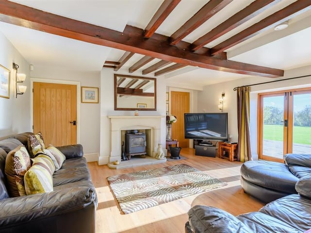 The lovely lounge has French doors leading out on to the substantial patio. It also features a stunning stone fireplace with inset multi-fuel stove, laminate floor, beamed ceiling and connecting doors to the snug and dining room.