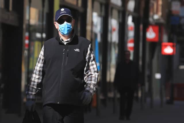 A shopper wears a face mask (Photo by Lindsey Parnaby / AFP) (Photo by LINDSEY PARNABY/AFP via Getty Images)