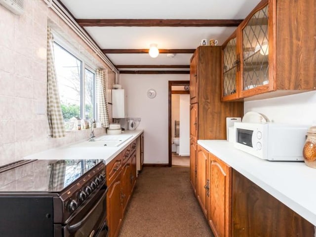 This our first look at the kitchen. It is an unusual shape, but it provides space for all the appliances and storage that you need.
