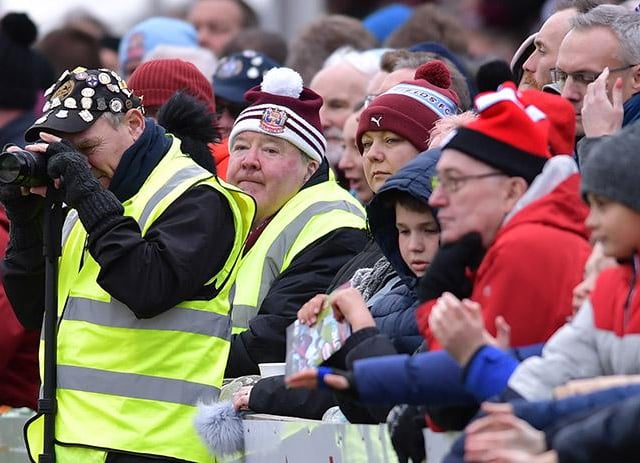 Fans huddle together to watch the action.