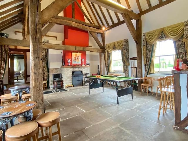 The central hall is a stunning, church-like reception room with a vaulted ceiling rising some 20 feet, flagstone flooring and exposed brickwork. There are two windows, four radiators and an open fireplace with surround stove.